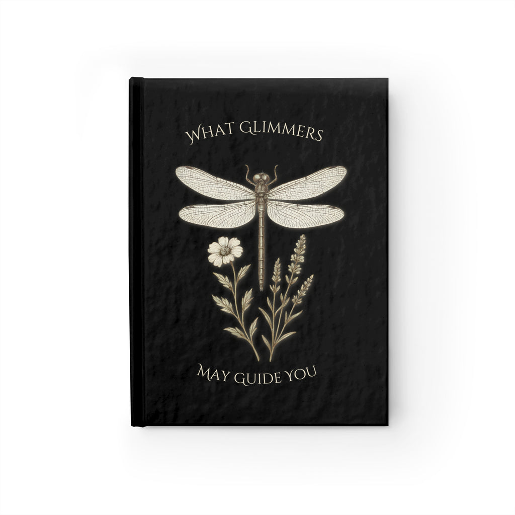 Black notebook with dragonfly and floral design on a white background. "What Glimmers May Guide You" Dragonfly Journal