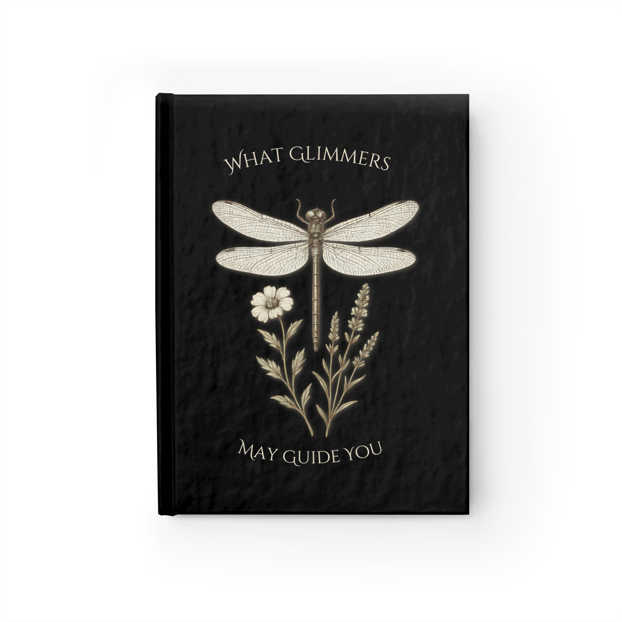 Black notebook with dragonfly and floral design on a white background. "What Glimmers May Guide You" Dragonfly Journal
