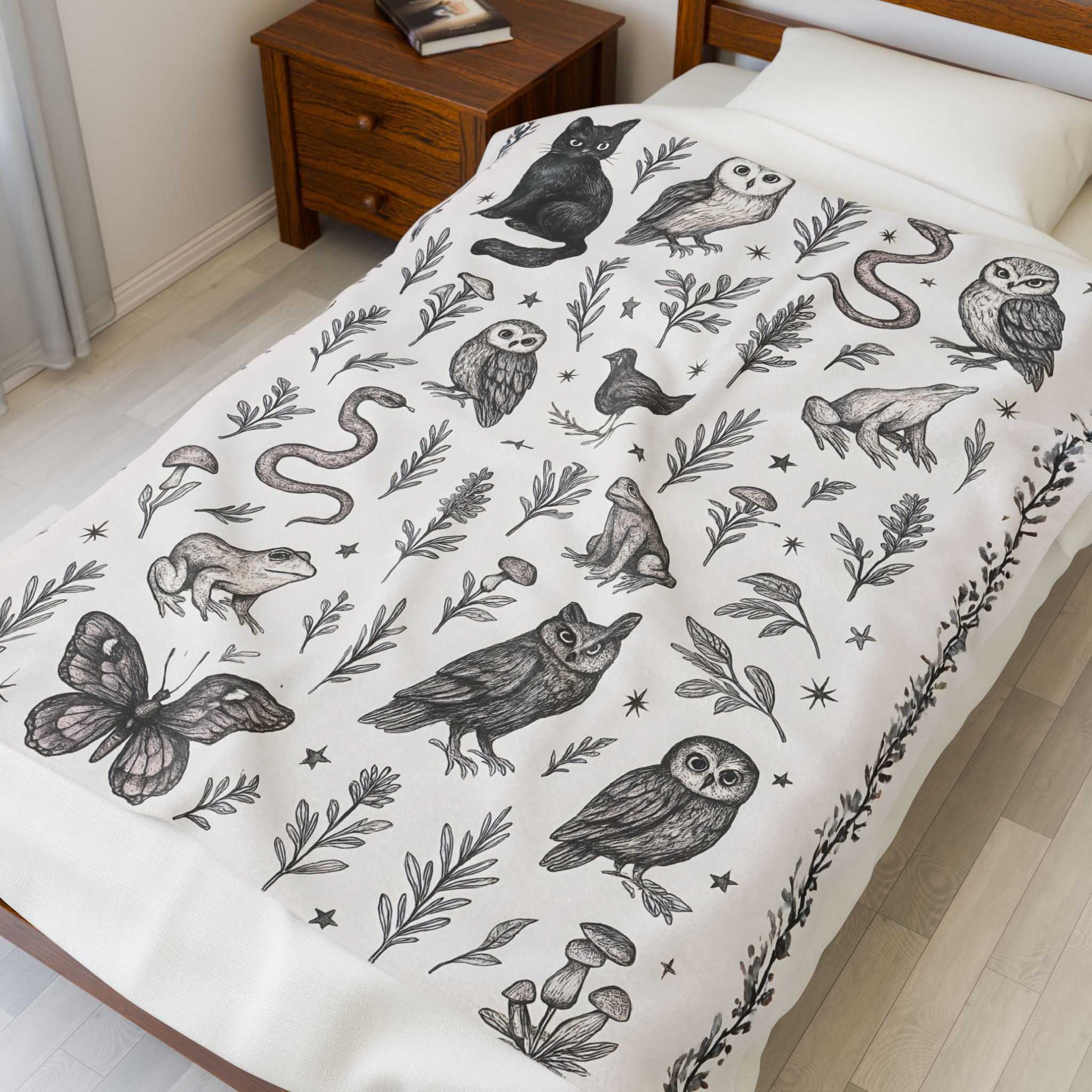 Bedspread with black animal and nature pattern on a white bed