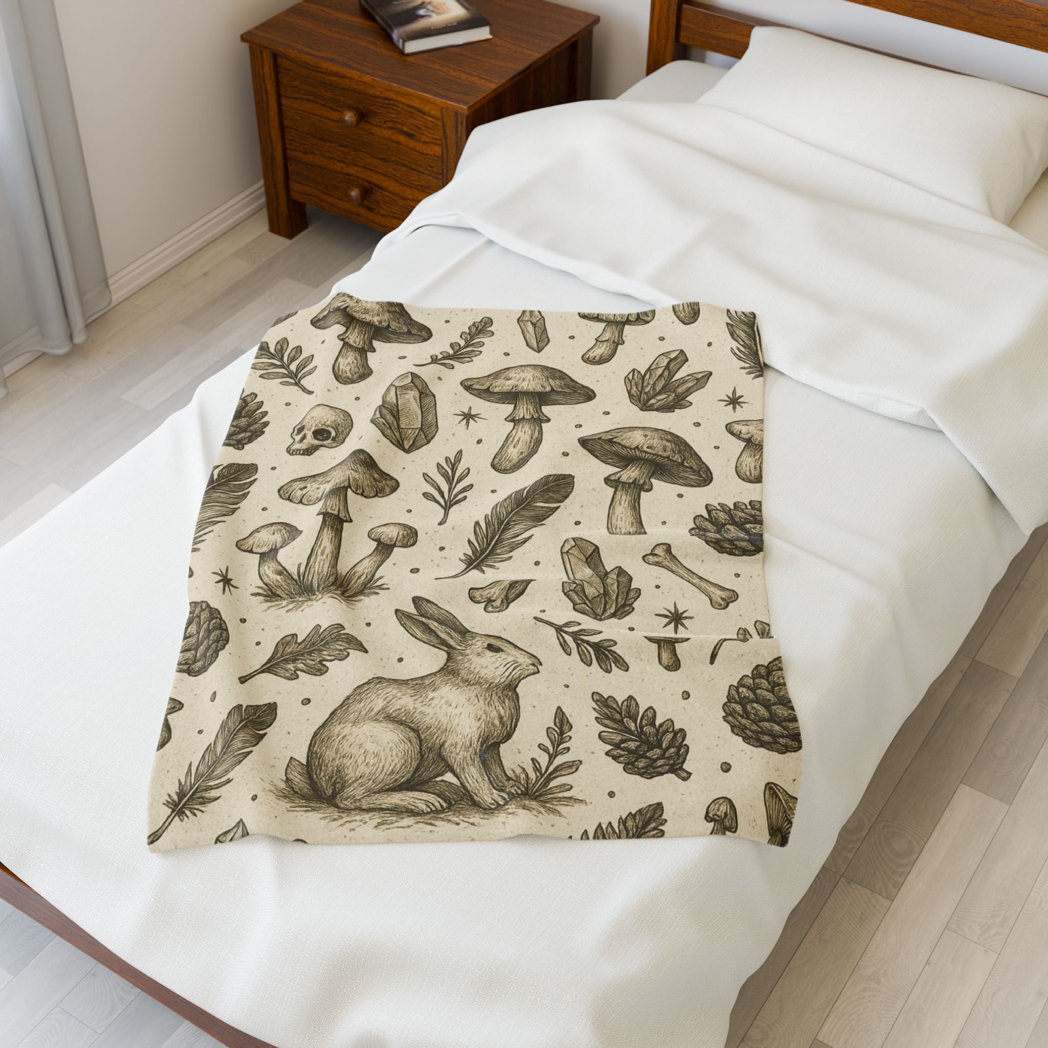 Blanket with nature-themed design featuring a rabbit, mushrooms, and leaves on a bed.